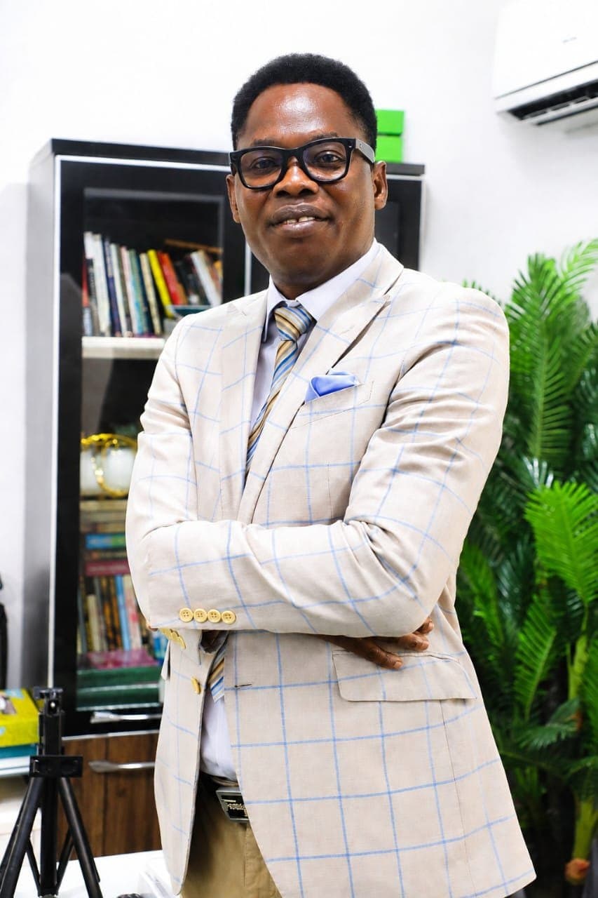 Wole Abraham Martins standing with arms crossed in his study